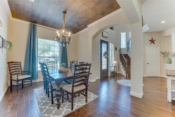 a dining room with furniture a chandelier and wooden floor