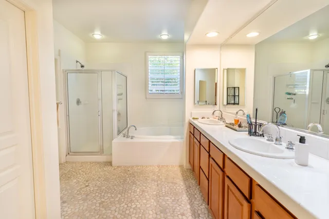 a bathroom with a double vanity sink mirror and a bathtub