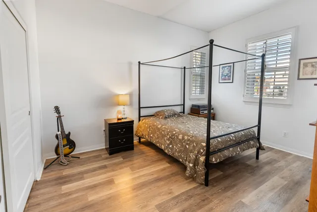 a bedroom with a bed and wooden floor