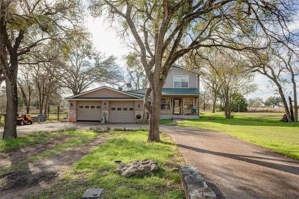 a view of large house with a big yard and large trees