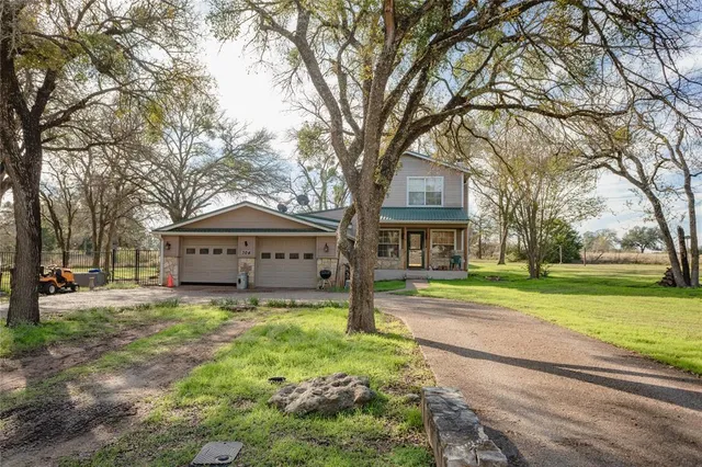 a view of large house with a big yard and large trees