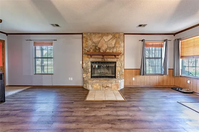 an empty room with wooden floor and fireplace