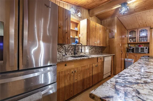 a kitchen with stainless steel appliances granite countertop a refrigerator and a sink