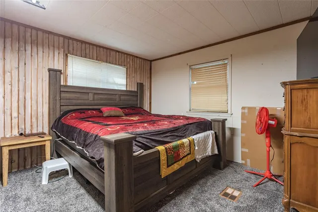 a bed sitting in a bedroom next to a window