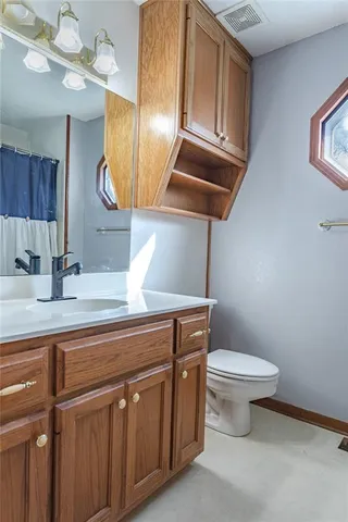 a bathroom with a toilet a sink and mirror
