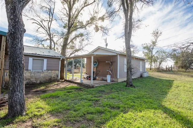 a view of a house with a yard and sitting area