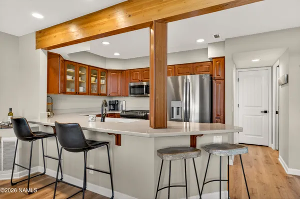 a kitchen with stainless steel appliances kitchen island granite countertop a refrigerator and a stove top oven