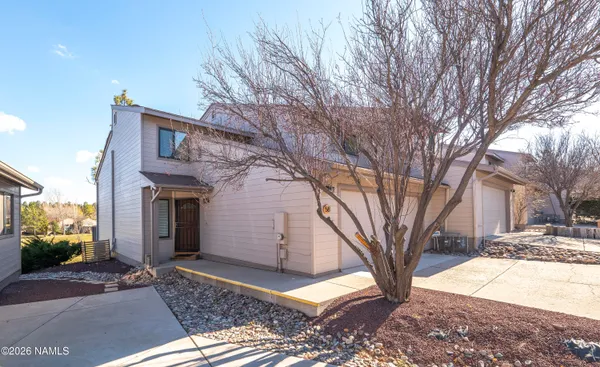 a view of a house with a yard and tree