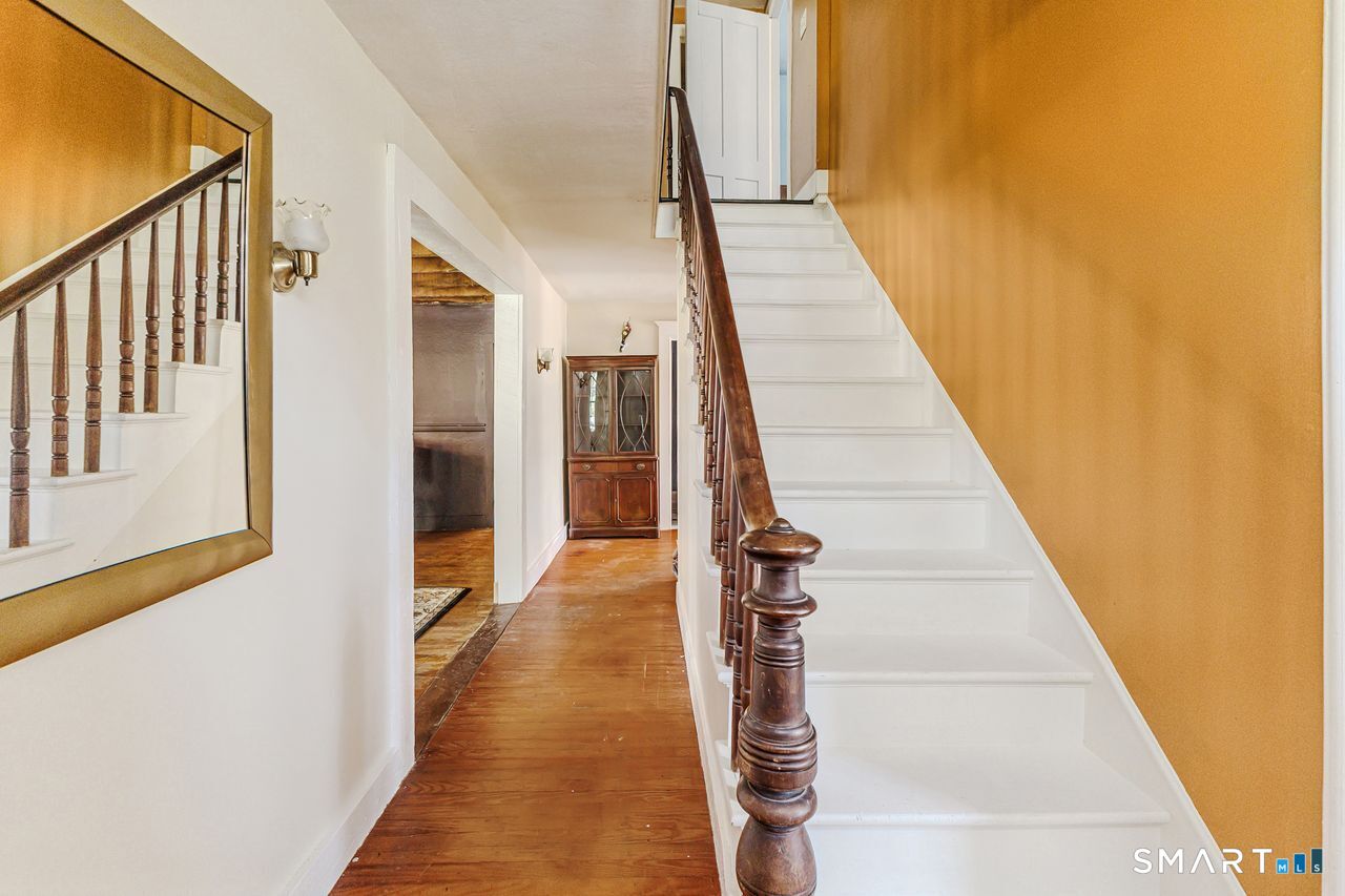 760 Upper Maple Street Killingly, CT 06239 - Photo 9 of 34 a view of a hallway with wooden floor and staircase