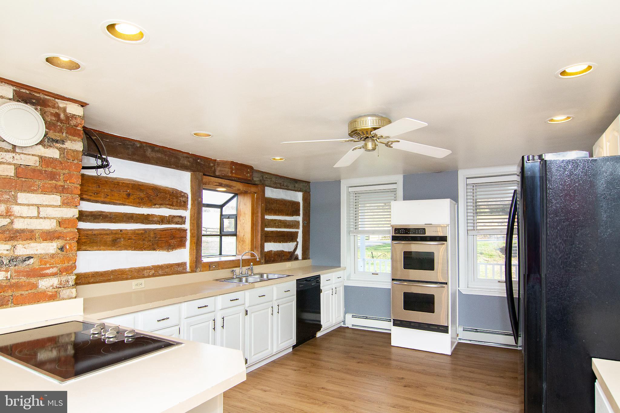 400 Leppo Road Westminster, MD 21158 - Photo 8 of 59 a kitchen with stainless steel appliances a stove a sink and white cabinets with wooden floor