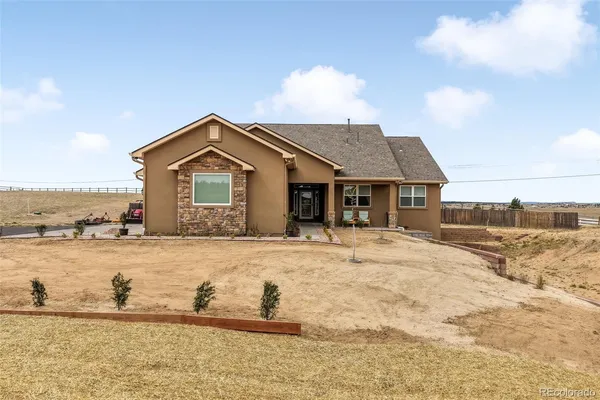 a front view of a house with a yard and lake view