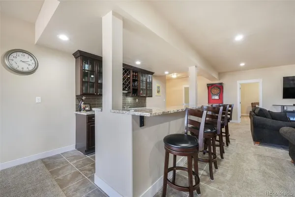 a kitchen with stainless steel appliances granite countertop a dining table chairs and stove top oven