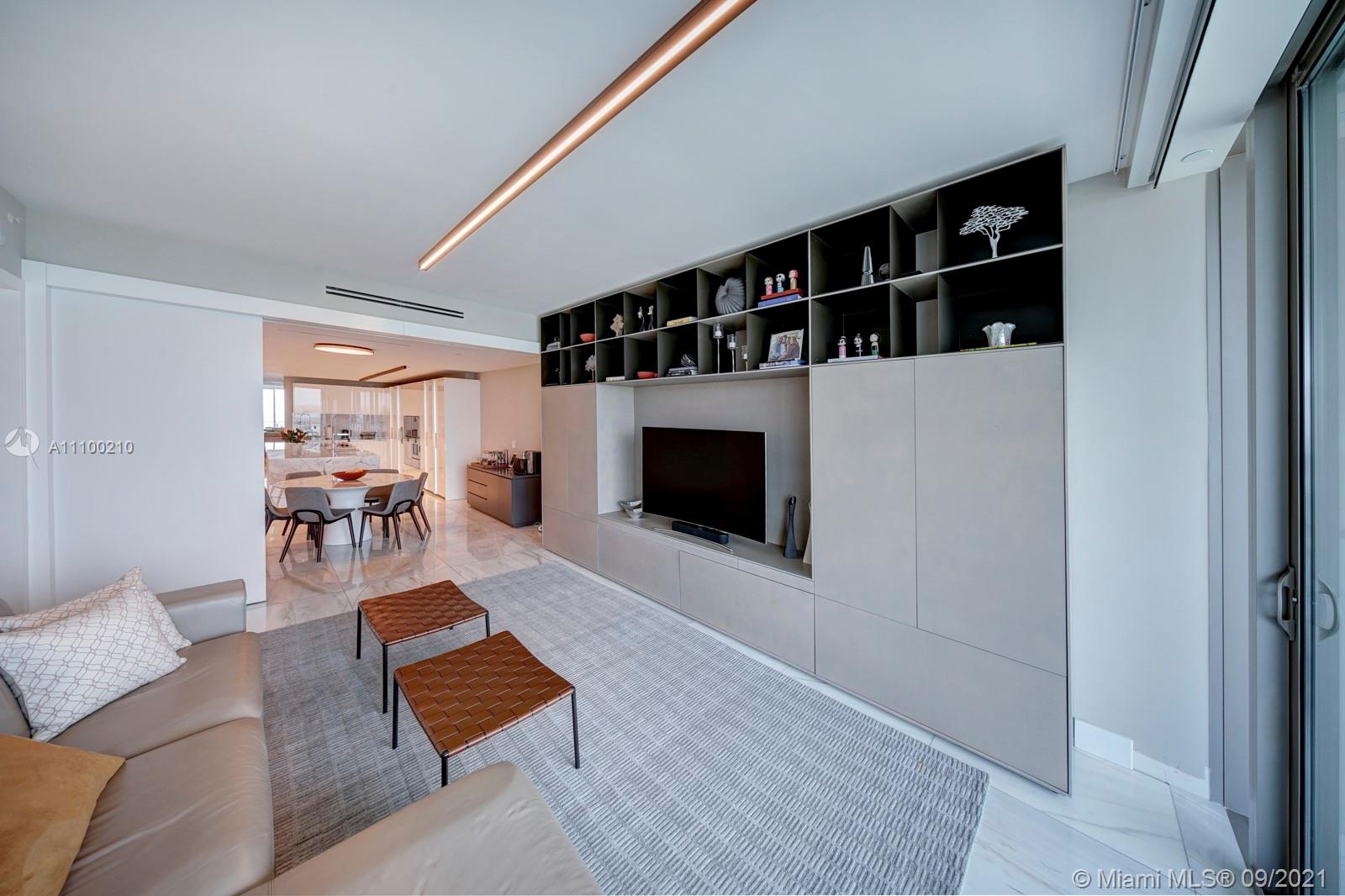 10203 Collins Avenue, Unit 1802 Bal Harbour, FL 33154 - Photo 14 of 43 a living room with furniture a rug and a fireplace