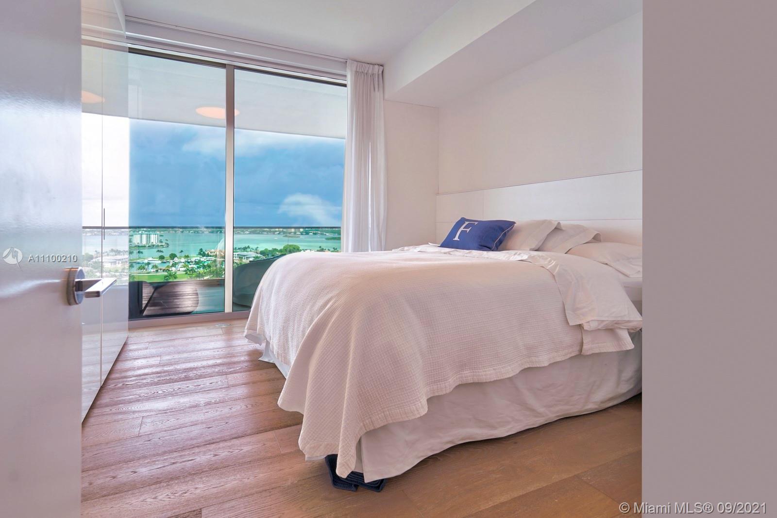 10203 Collins Avenue, Unit 1802 Bal Harbour, FL 33154 - Photo 32 of 43 a bed sitting in a bedroom next to a window