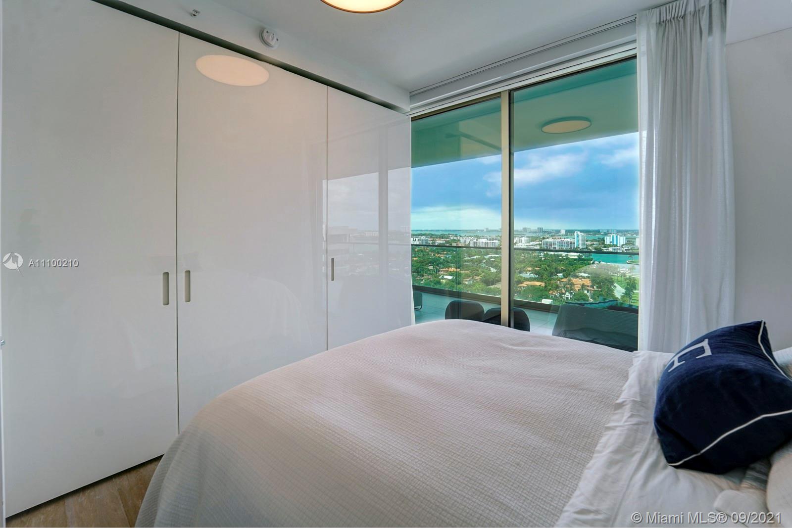 10203 Collins Avenue, Unit 1802 Bal Harbour, FL 33154 - Photo 36 of 43 a bedroom with a large window and a balcony