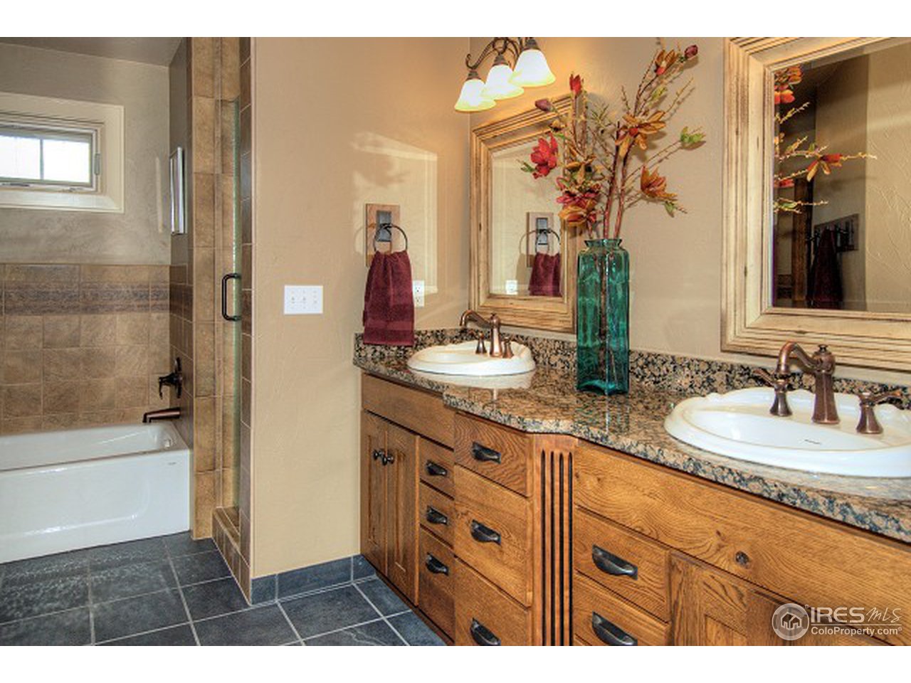 3850 Spring Valley Road Boulder, CO 80304 - Photo 15 of 25 a bathroom with a double vanity sink a mirror and a bathtub