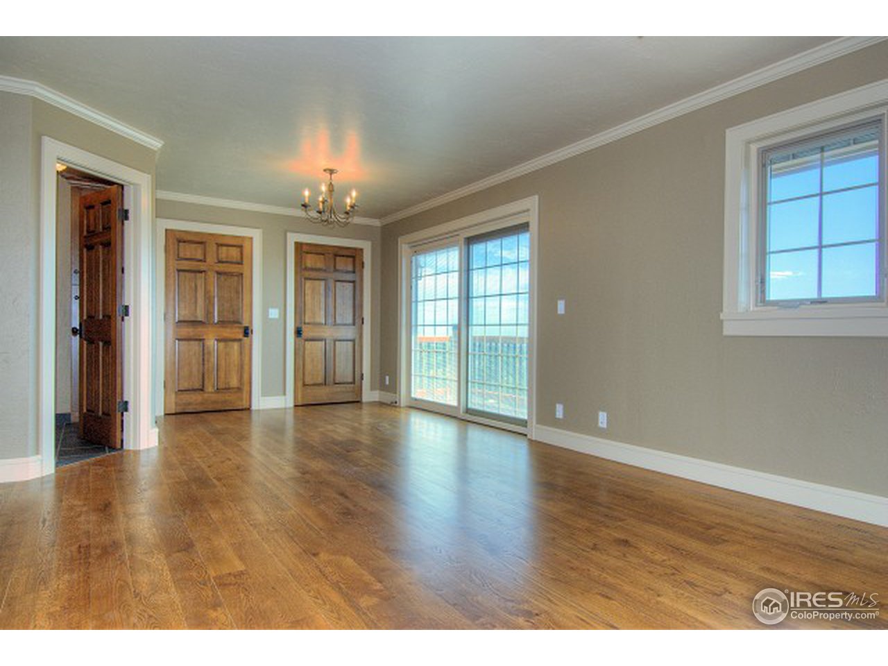 3850 Spring Valley Road Boulder, CO 80304 - Photo 17 of 25 an empty room with wooden floor chandelier and windows