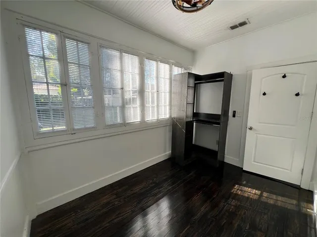 a kitchen with a refrigerator and wooden floor