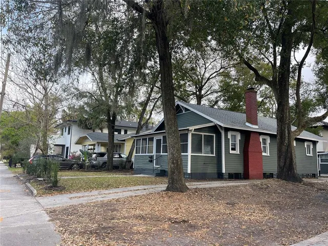 a view of a house with a large tree in front of it