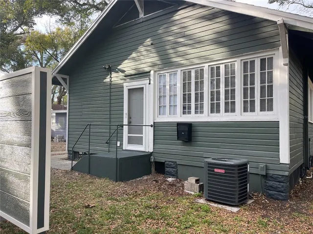 a view of a house with backyard and wooden fence