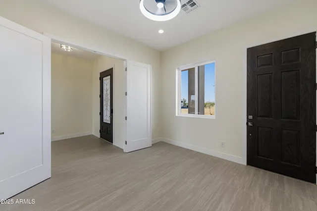 a view of empty room with wooden floor and window