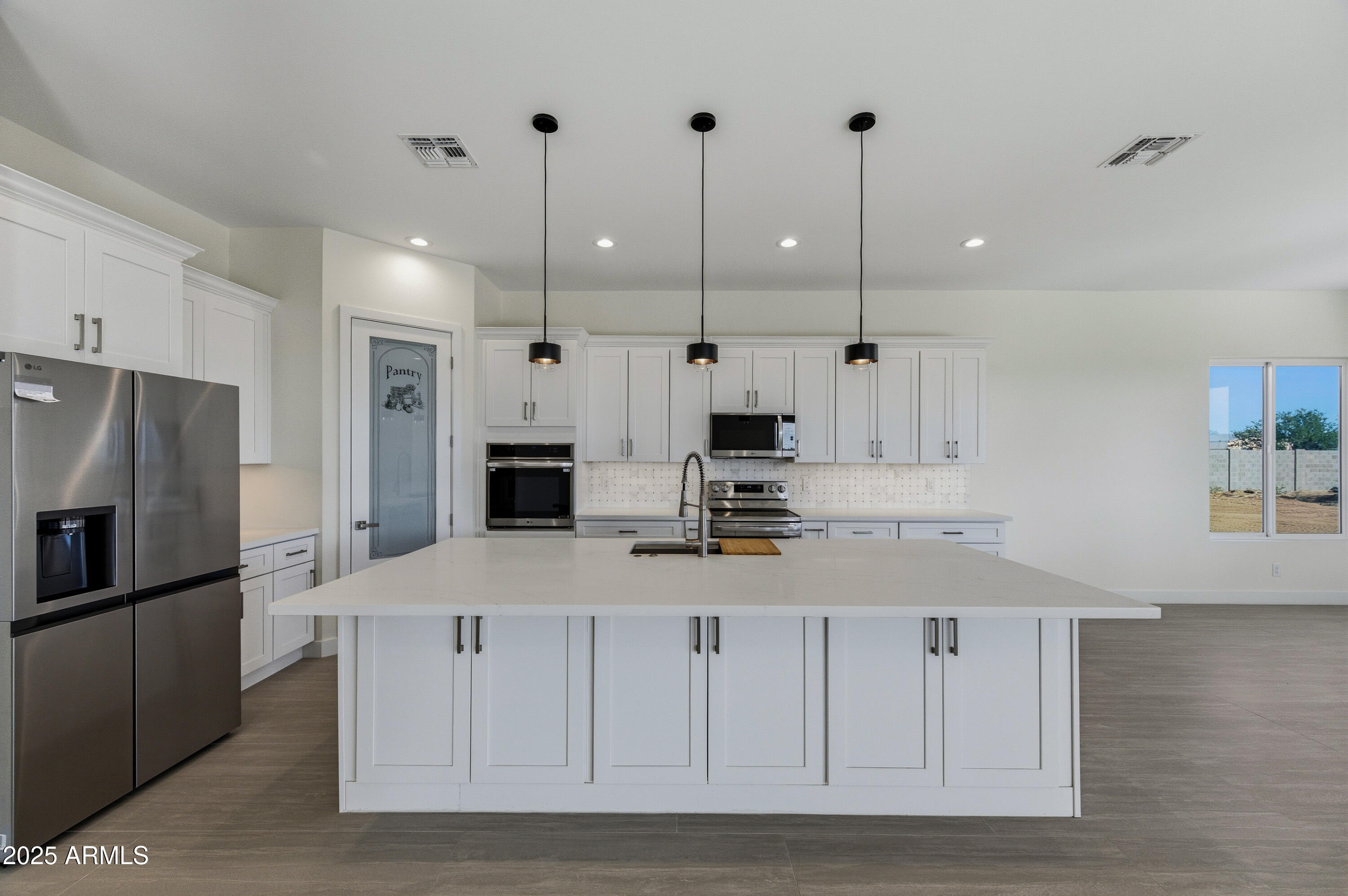 10039 North Burris Road Casa Grande, AZ 85122 - Photo 40 of 61 a kitchen with kitchen island white cabinets and stainless steel appliances