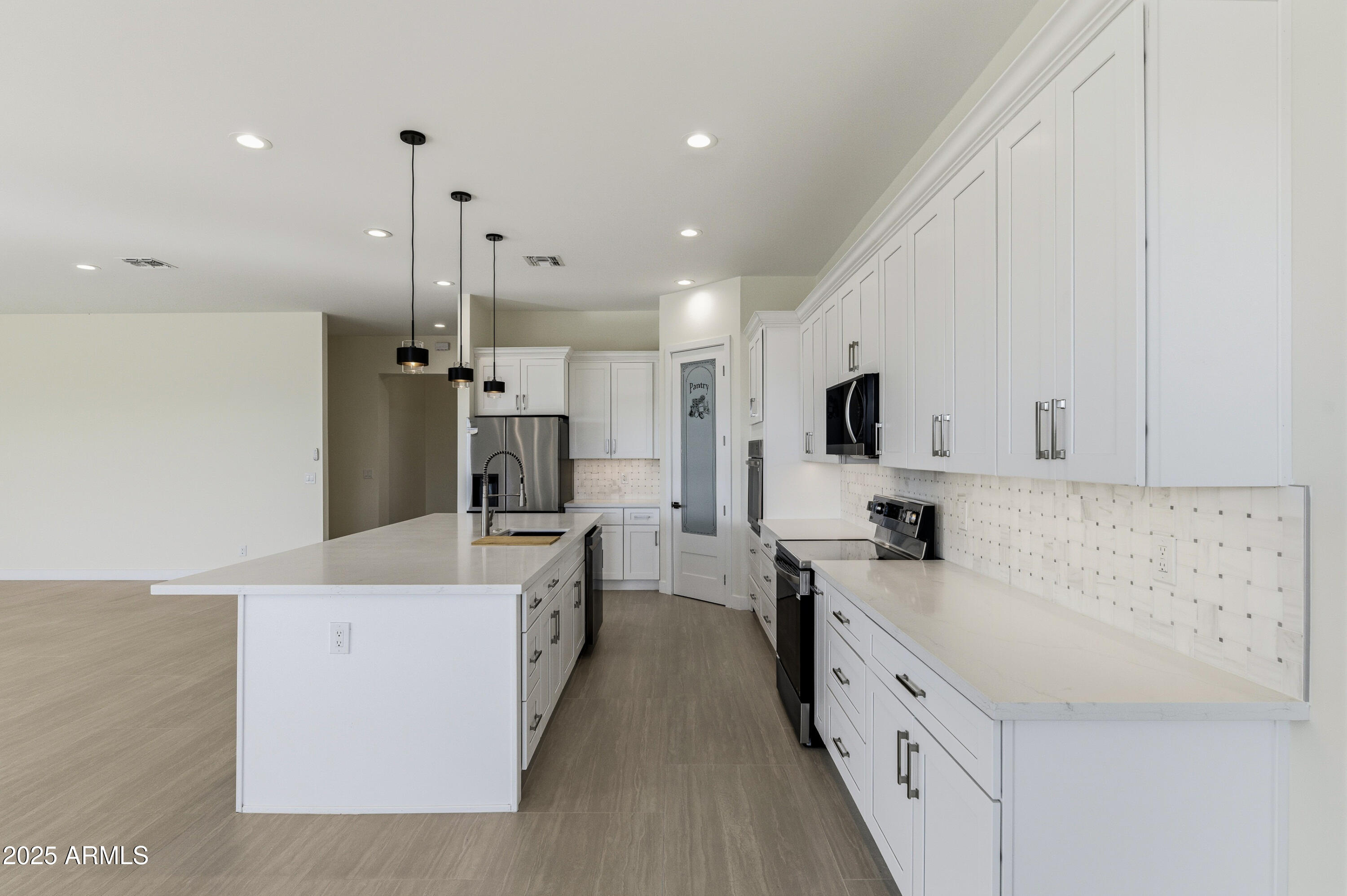 10039 North Burris Road Casa Grande, AZ 85122 - Photo 43 of 61 a large kitchen with stainless steel appliances kitchen island granite countertop a refrigerator a stove and a sink with wooden floor