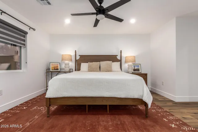a bedroom with a bed and a ceiling fan
