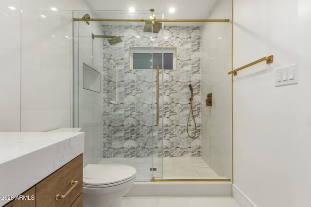 a bathroom with a sink mirror vanity and toilet