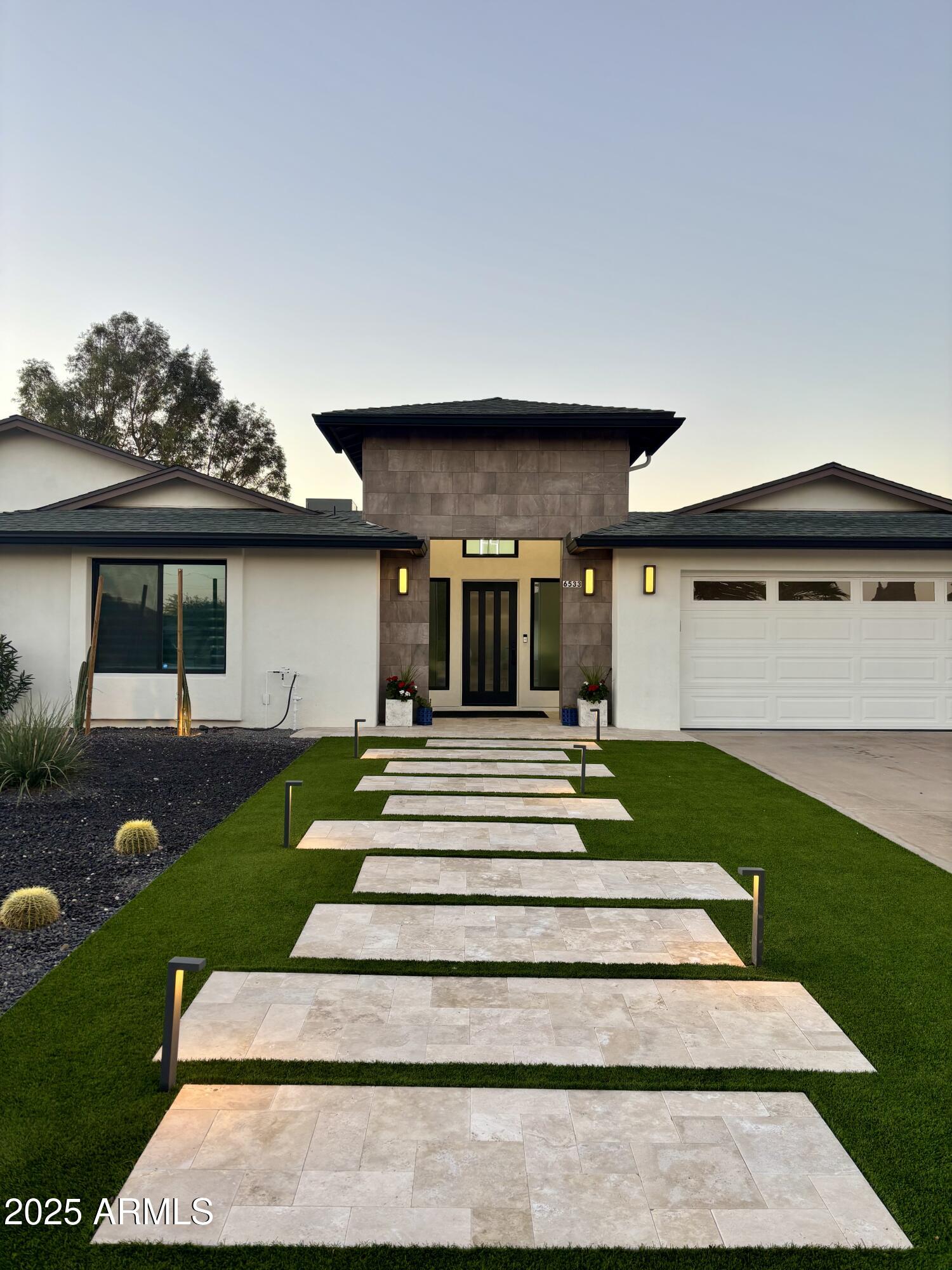 6533 East Phelps Road Scottsdale, AZ 85254 - Photo 2 of 6 a view of a house with a yard potted plants and a table