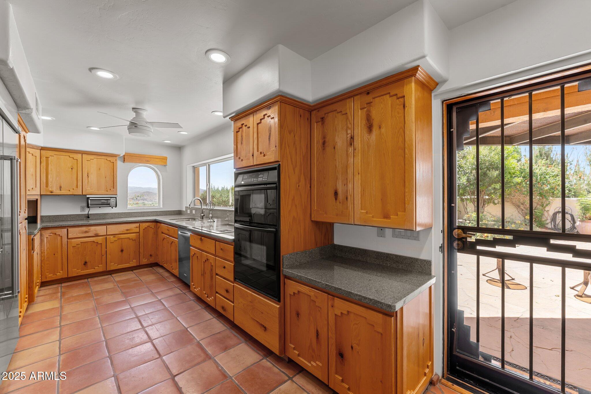 651 Chaparral Road Wickenburg, AZ 85390 - Photo 22 of 58 a kitchen with stainless steel appliances granite countertop a stove a sink and a microwave