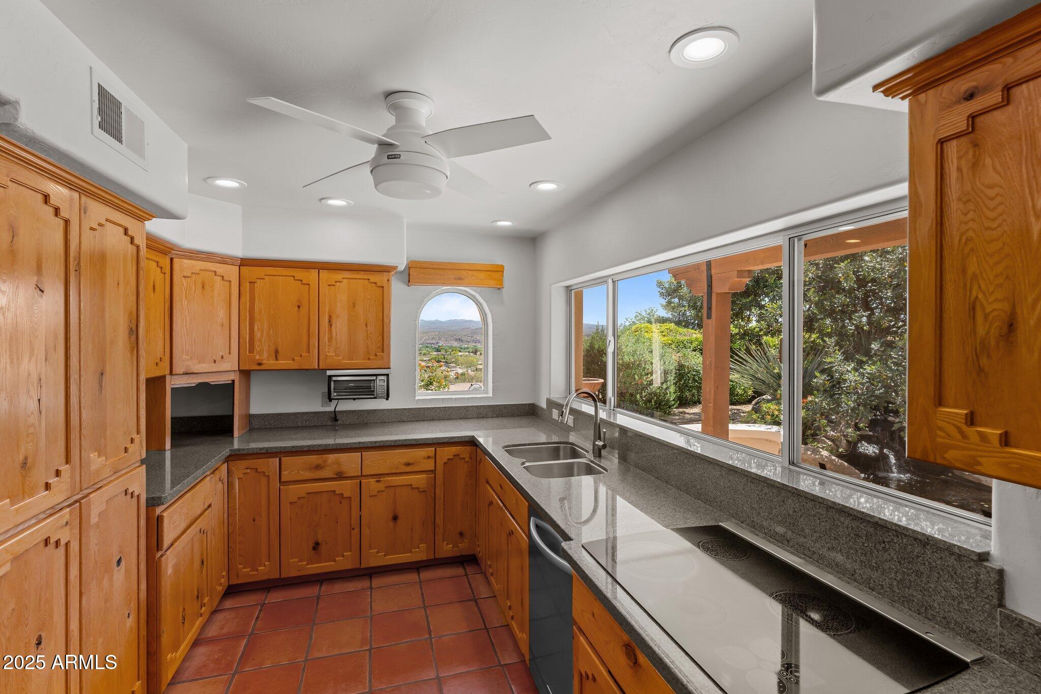 651 Chaparral Road Wickenburg, AZ 85390 - Photo 25 of 58 a kitchen with a sink appliances cabinets and a large window