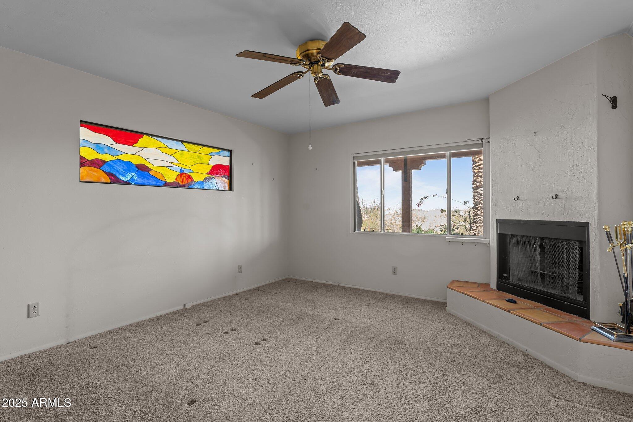 651 Chaparral Road Wickenburg, AZ 85390 - Photo 29 of 58 an empty room with windows and fireplace