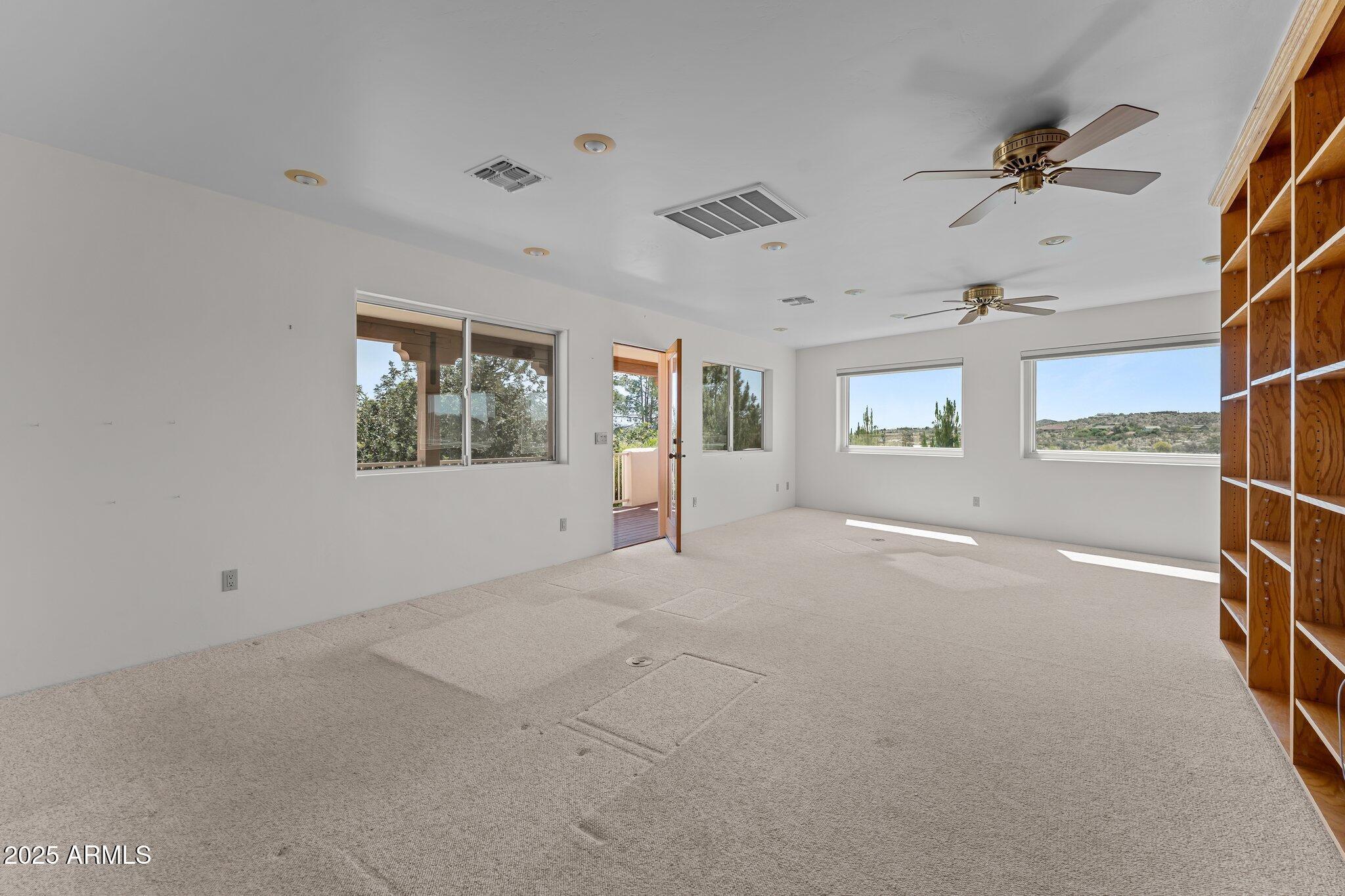 651 Chaparral Road Wickenburg, AZ 85390 - Photo 41 of 58 en empty room with windows and ceiling fan