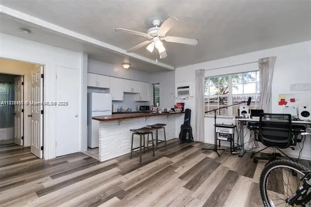 a view of living room kitchen with stainless steel appliances wooden floor and furniture