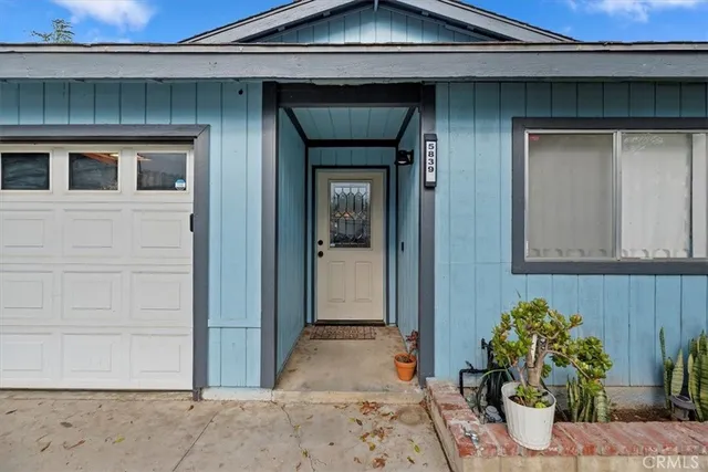 a front view of a house with potted plants