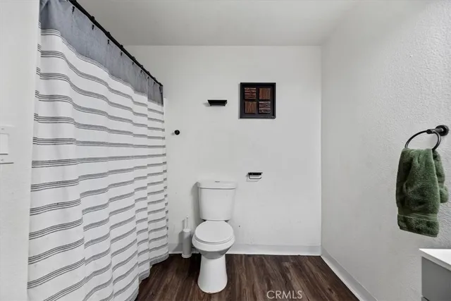 a bathroom with a toilet and a shower curtain