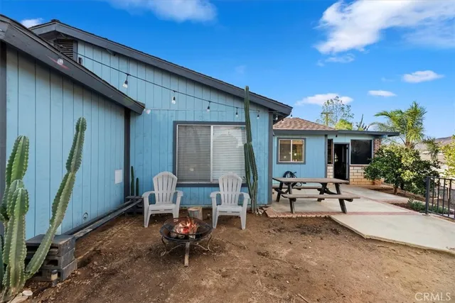a view of a house with backyard sitting area and garden