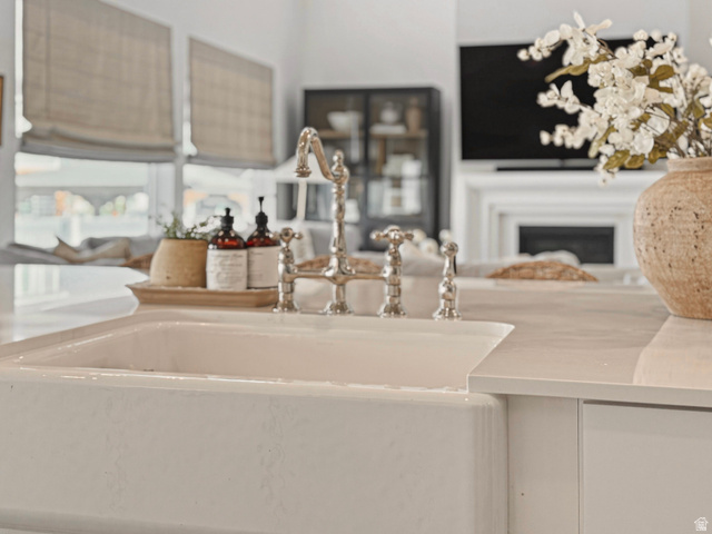 870 North Ada Loop Lehi, UT 84048 - Photo 12 of 51 White farmhouse-style sink with a polished nickel bridge faucet, set into a light-toned countertop
