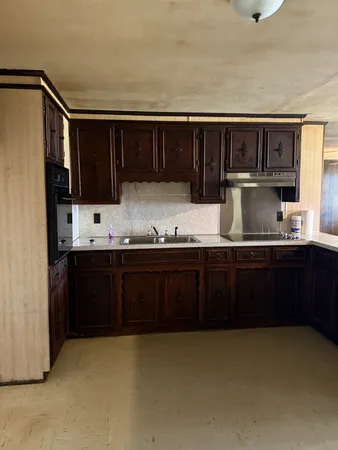 a kitchen with kitchen island granite countertop a sink cabinets and stainless steel appliances