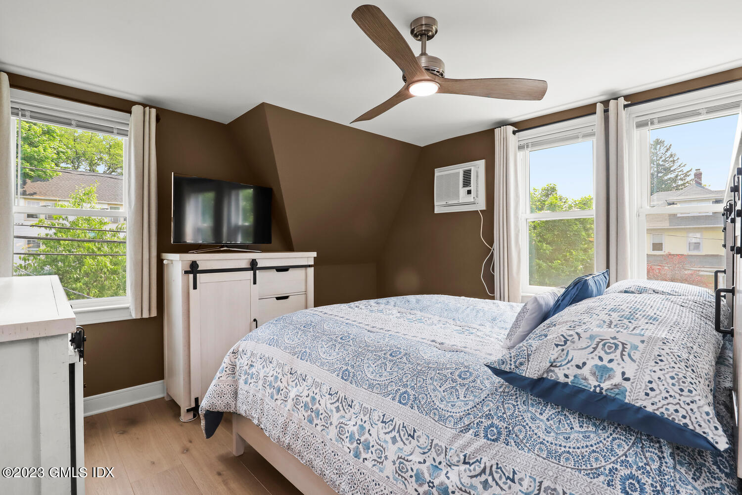 5 Oxer Place Greenwich, CT 06830 - Photo 24 of 37 a bedroom with a bed and a flat tv screen next to a window