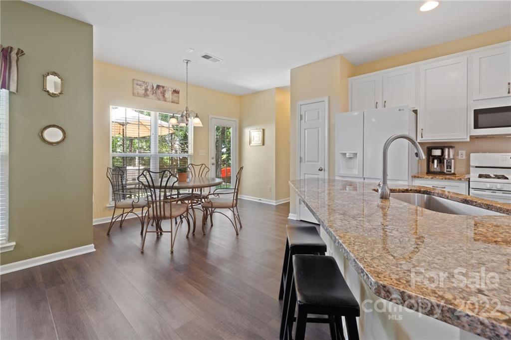 4905 Missi Lane Fort Mill, SC 29708 - Photo 11 of 34 a kitchen with granite countertop a table chairs stove and sink