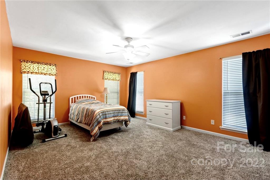 4905 Missi Lane Fort Mill, SC 29708 - Photo 28 of 34 a spacious bedroom with a bed and a chandelier