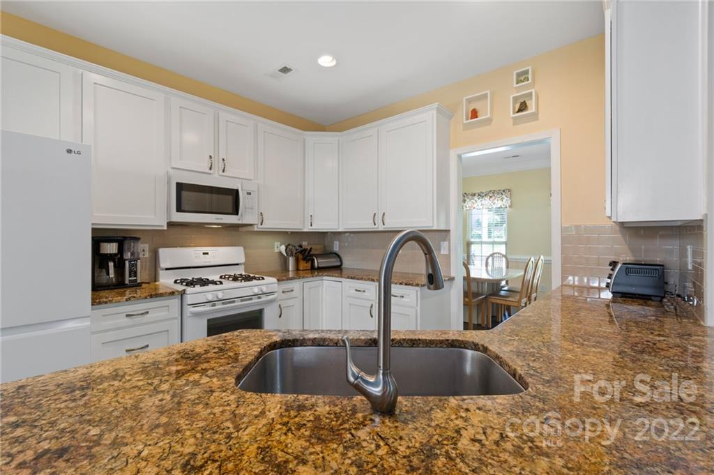 4905 Missi Lane Fort Mill, SC 29708 - Photo 9 of 34 a kitchen with granite countertop a stove sink and cabinets