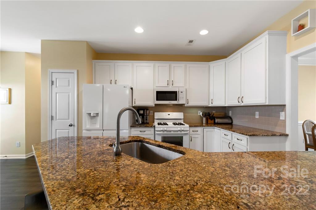 4905 Missi Lane Fort Mill, SC 29708 - Photo 10 of 34 a kitchen with granite countertop a stove a sink a microwave and refrigerator