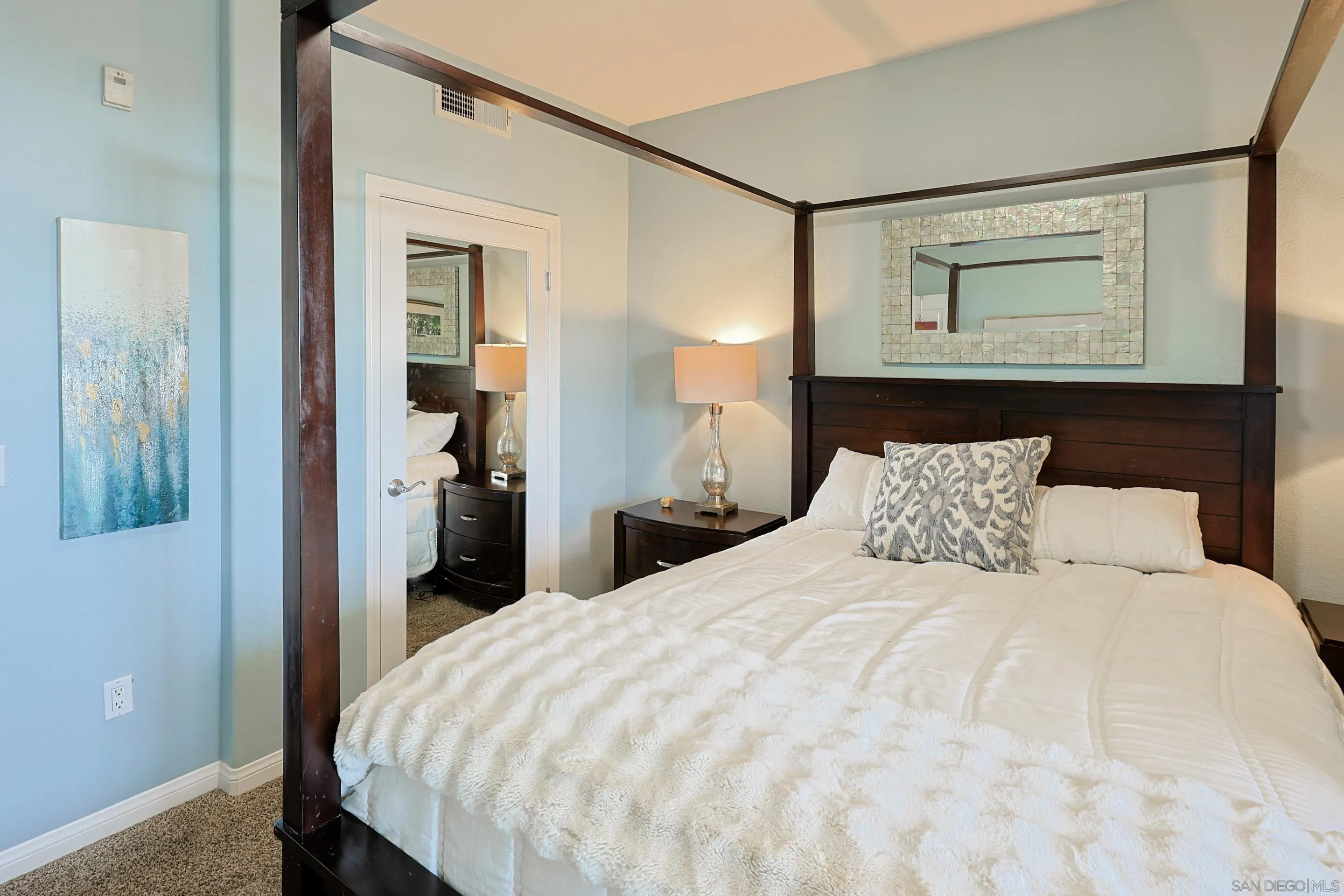 3887 Pell Place, Unit 229 San Diego, CA 92130 - Photo 14 of 49 a bedroom with a bed and a mirror