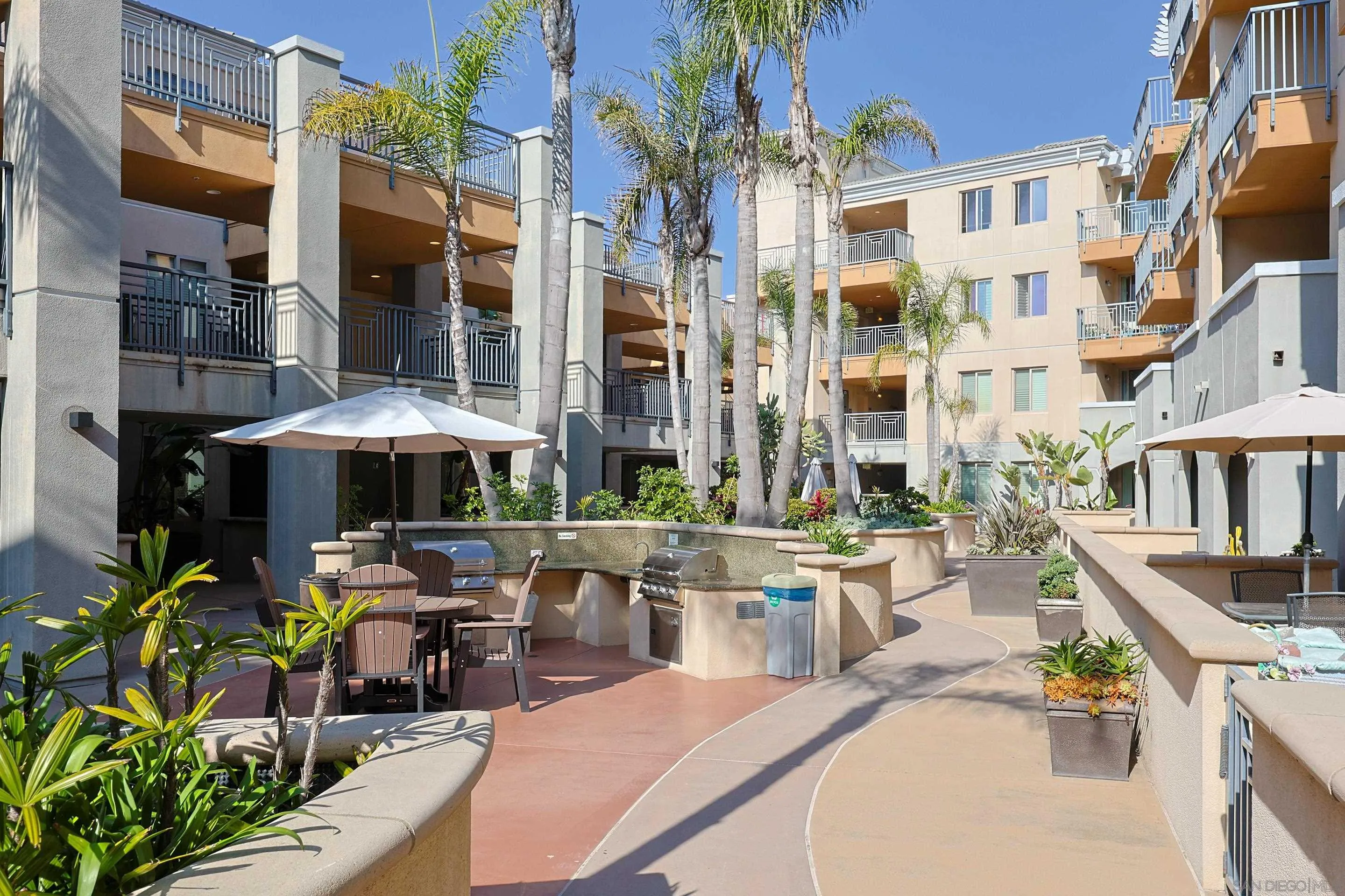 3887 Pell Place, Unit 229 San Diego, CA 92130 - Photo 48 of 49 a view of a patio with couches table and chairs under an umbrella with a barbeque