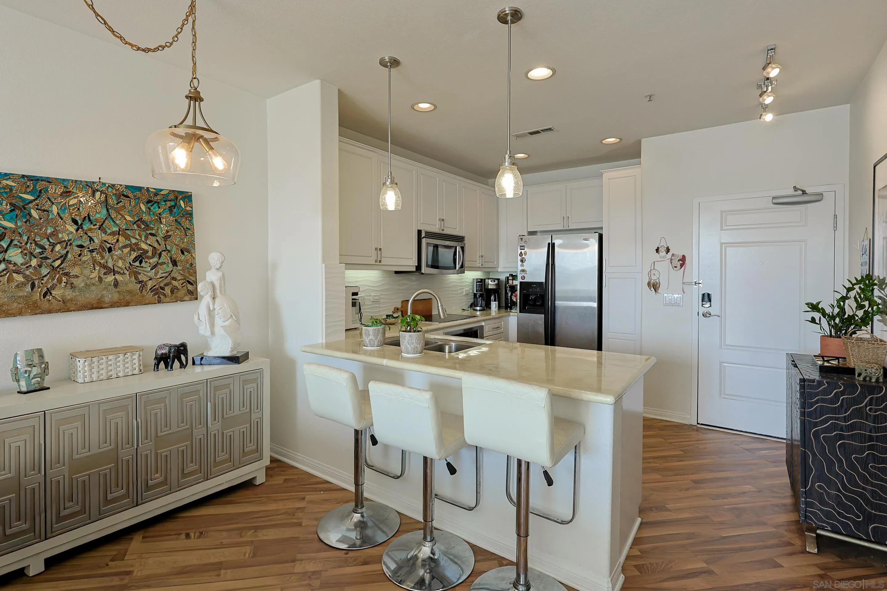 3887 Pell Place, Unit 229 San Diego, CA 92130 - Photo 6 of 49 a kitchen with stainless steel appliances granite countertop a refrigerator a sink dishwasher a stove and white cabinets with wooden floor