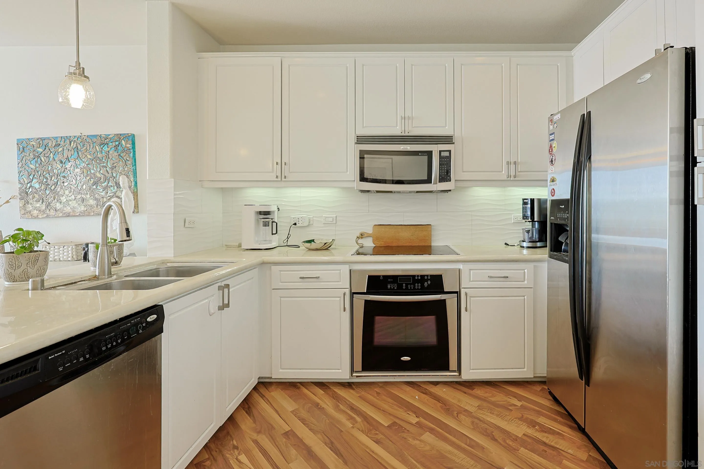 3887 Pell Place, Unit 229 San Diego, CA 92130 - Photo 8 of 49 a kitchen with white cabinets stainless steel appliances and sink
