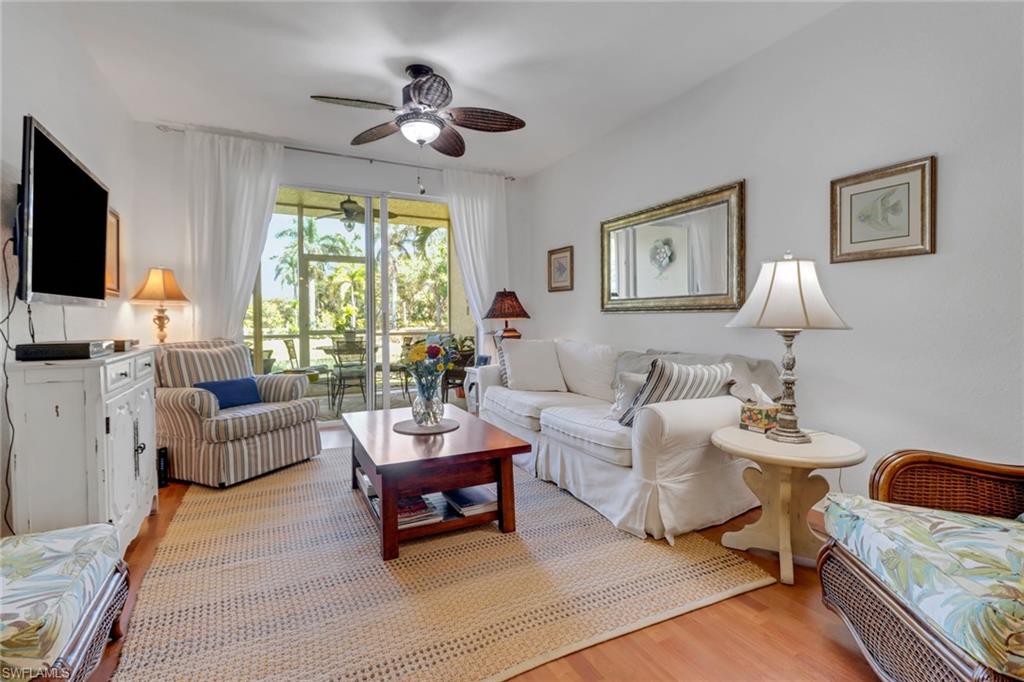 20140 Estero Gardens Circle, Unit 101 Estero, FL 33928 - Photo 11 of 40 a living room with furniture a flat screen tv and a large window